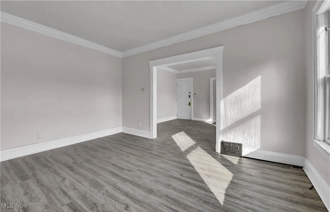 Empty room featuring crown molding and wood finished floors