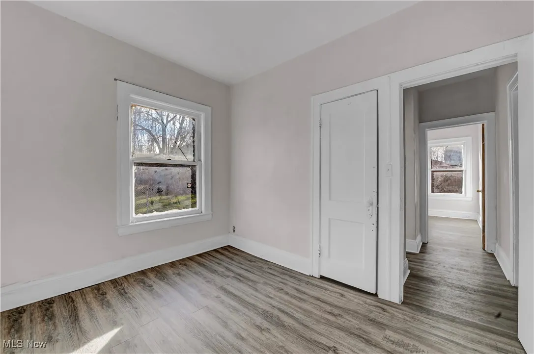 Unfurnished bedroom featuring light wood-style floors and multiple windows