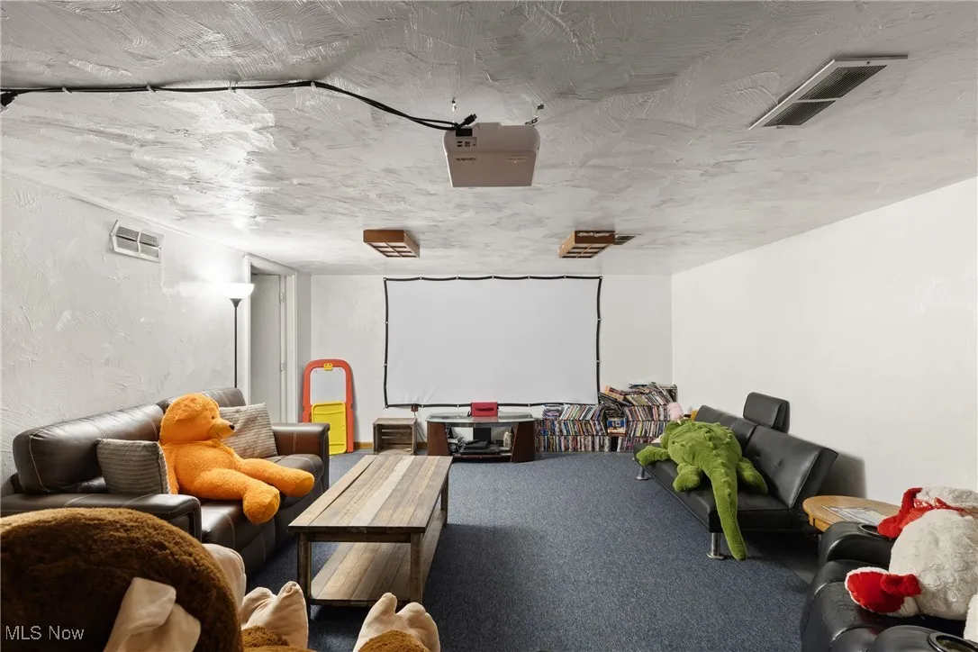 Carpeted cinema featuring a textured ceiling