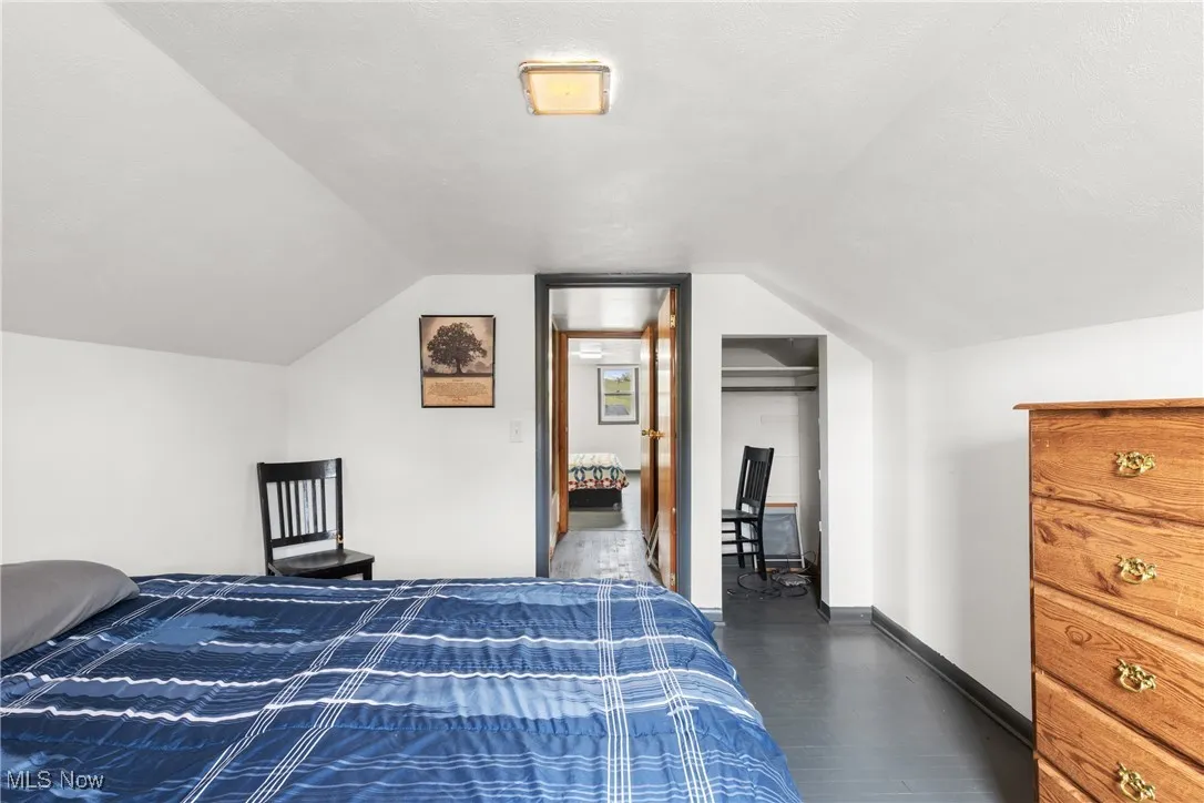 Bedroom featuring dark wood-type flooring and vaulted ceiling