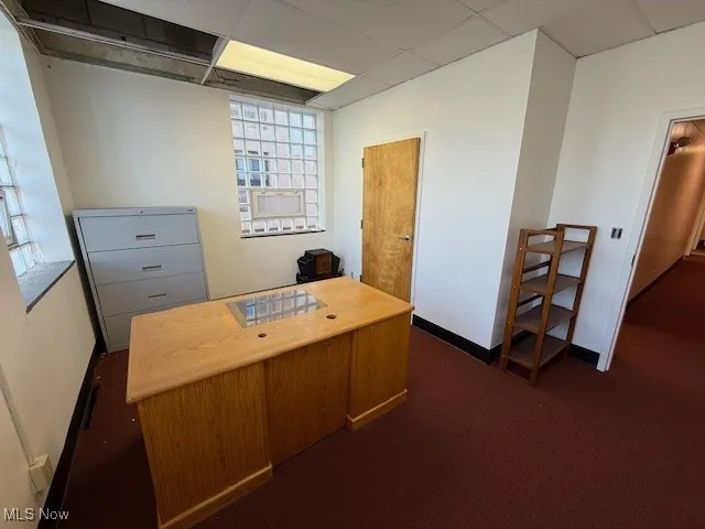 Office featuring a drop ceiling and dark carpet