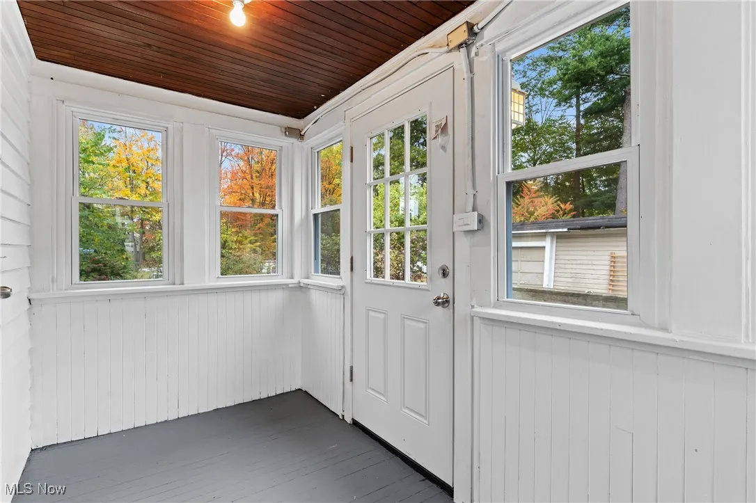 Doorway to outside with wooden walls, hardwood / wood-style floors, and wooden ceiling