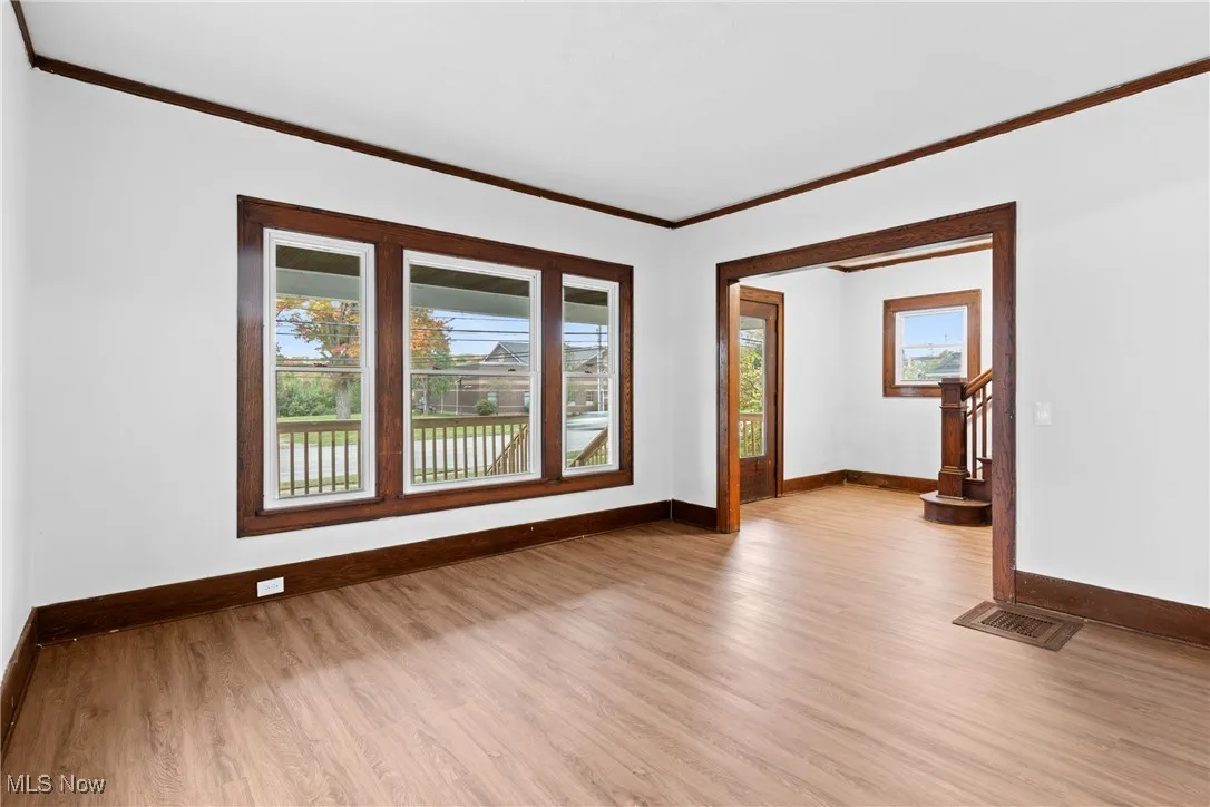 Spare room featuring crown molding and light wood-style floors
