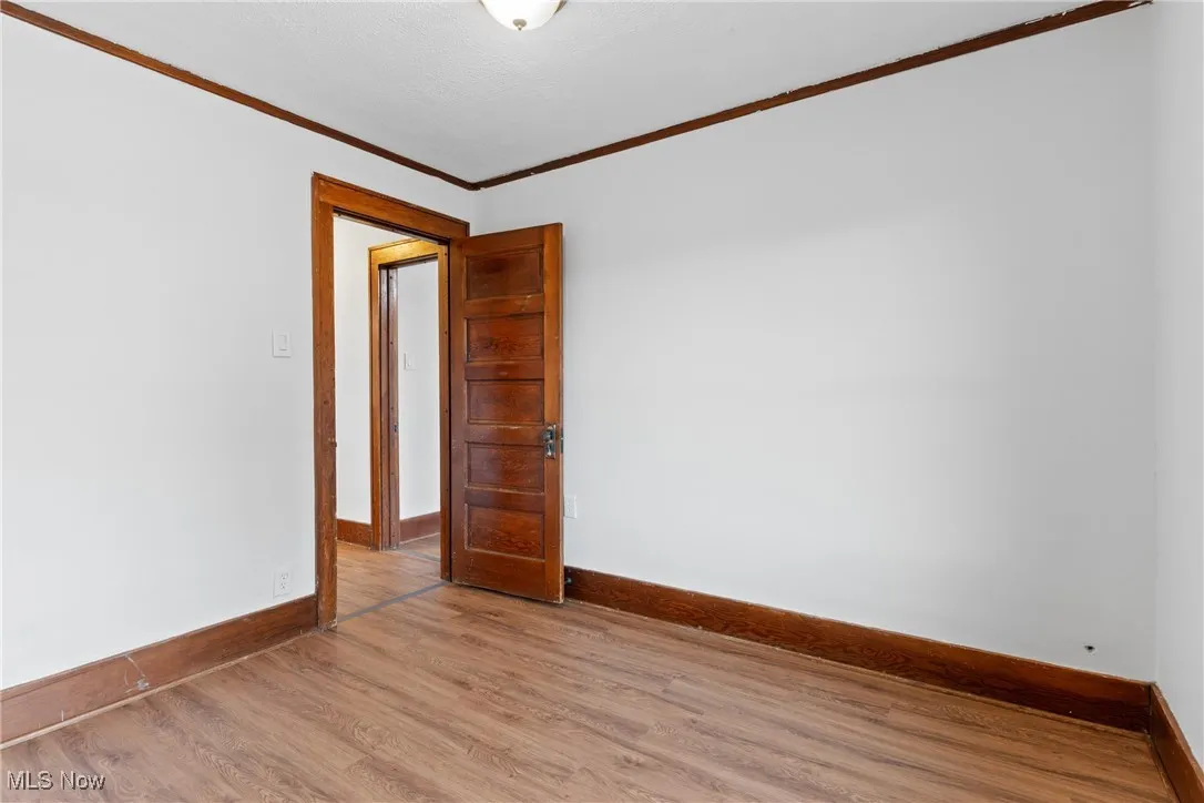 Spare room featuring ornamental molding and wood finished floors