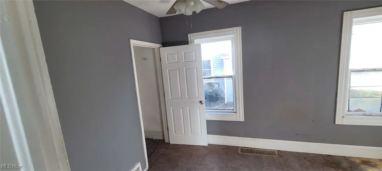 Empty room featuring baseboards and a ceiling fan