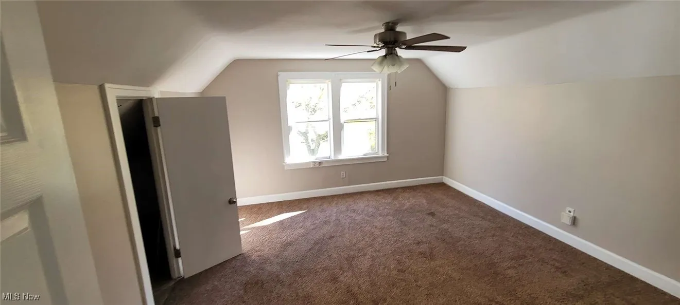 Bonus room with carpet, lofted ceiling, and ceiling fan
