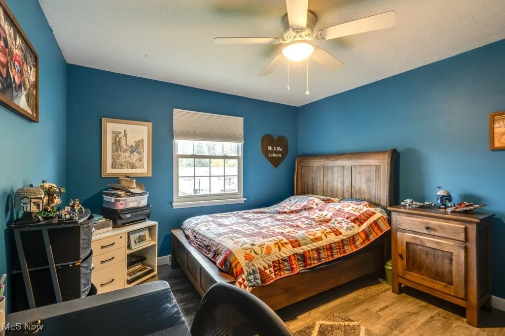 Bedroom featuring wood finished floors, ceiling fan, and a textured ceiling