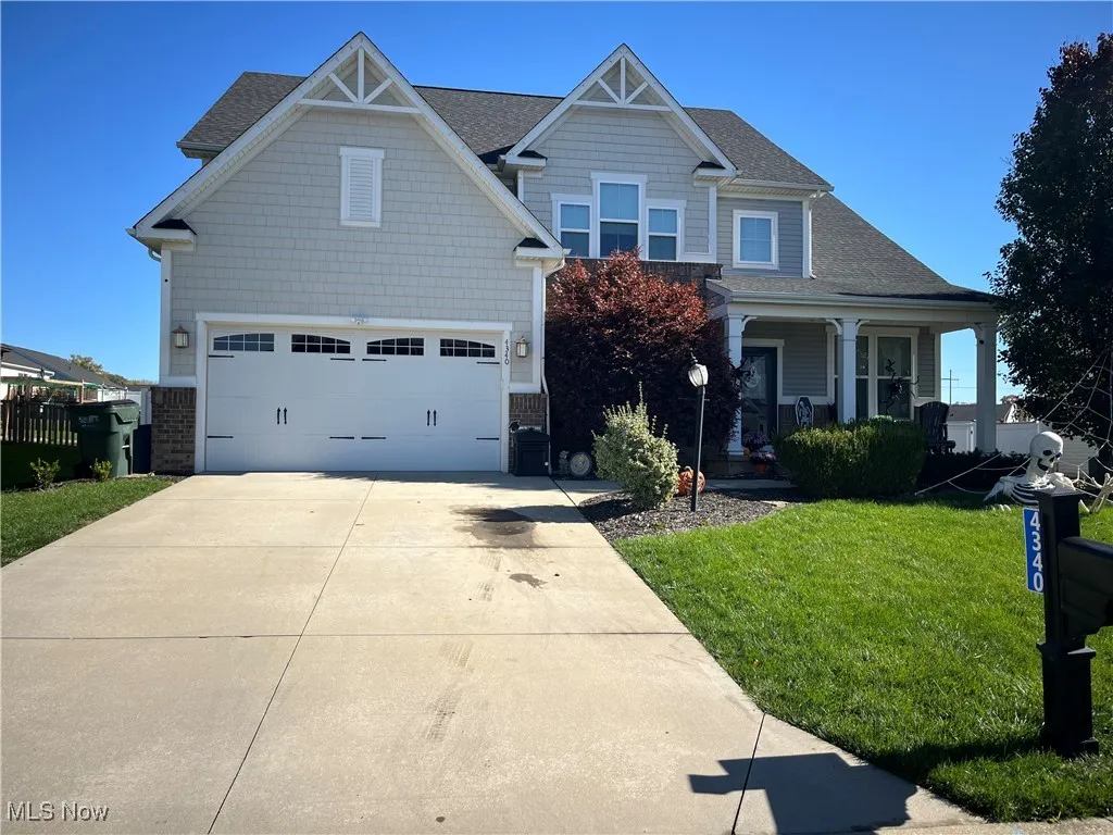 Craftsman inspired home with a front yard, a porch, concrete driveway, a garage, and roof with shingles