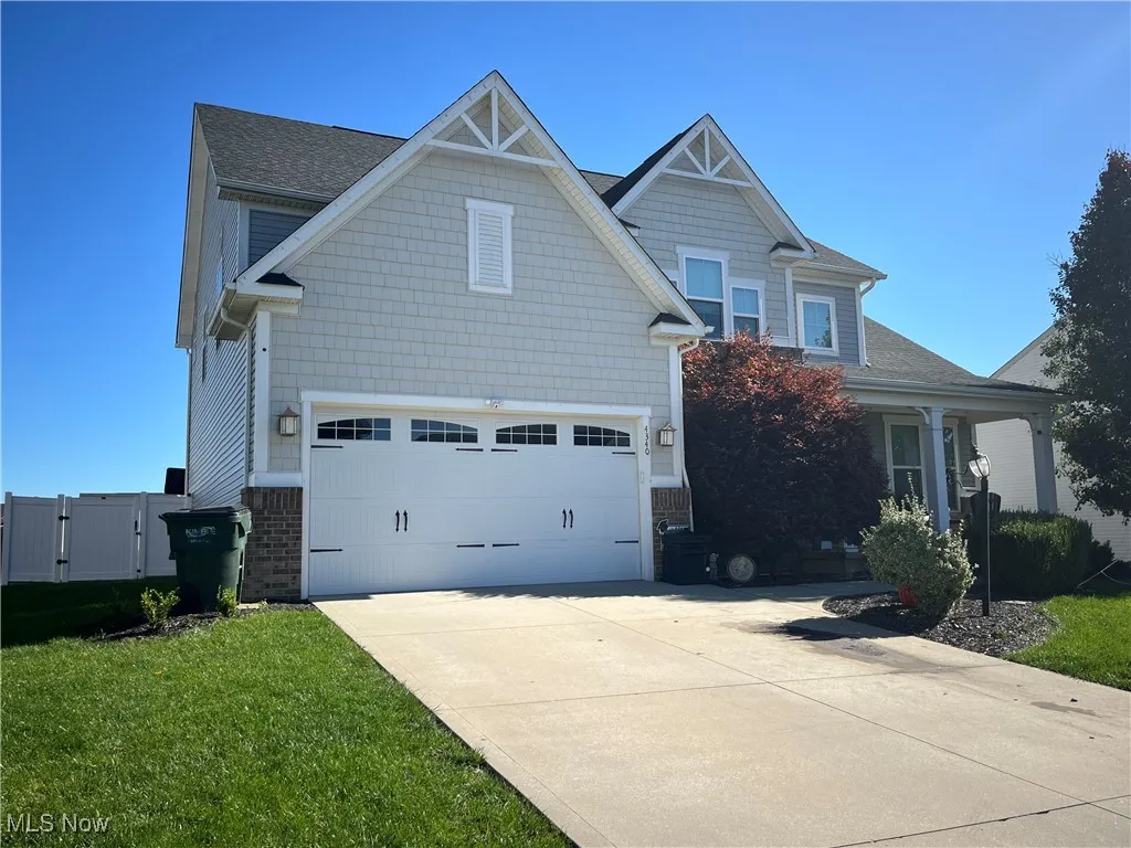 Craftsman inspired home with concrete driveway, a front yard, covered porch, and an attached garage