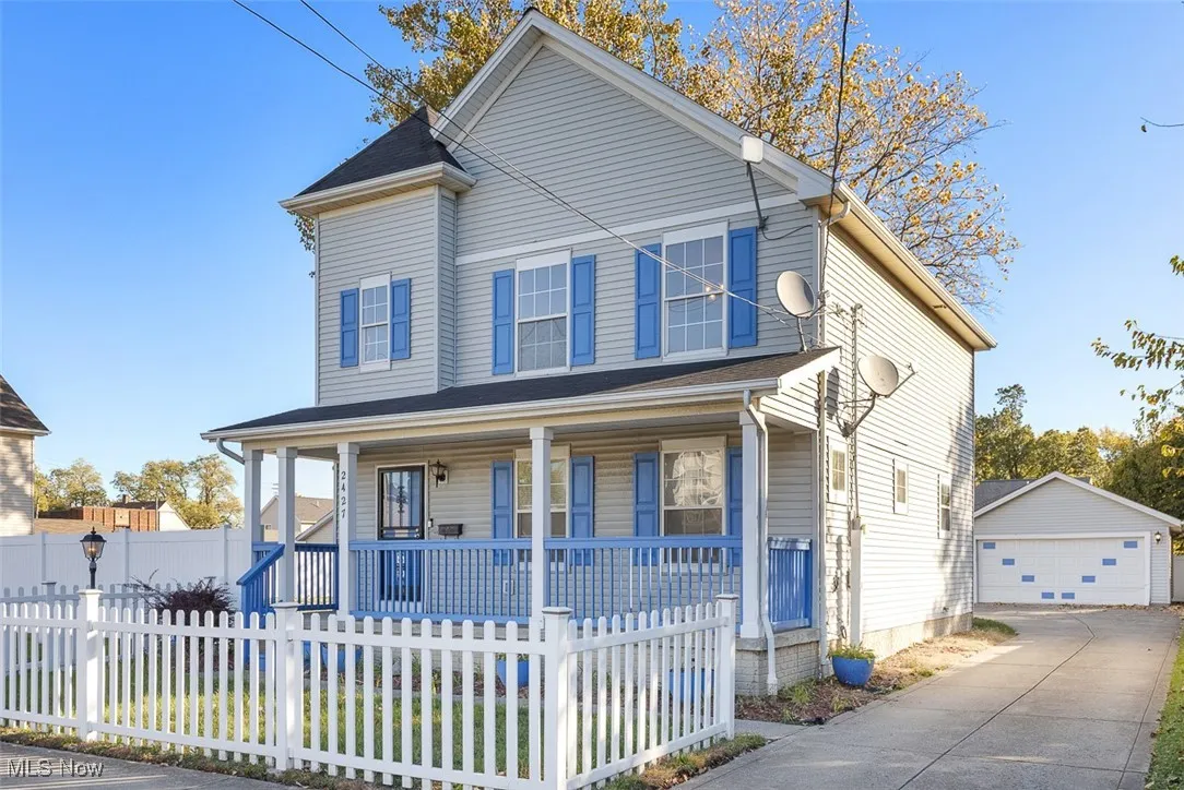 View of front facade featuring covered porch, a garage, and a fenced front yard