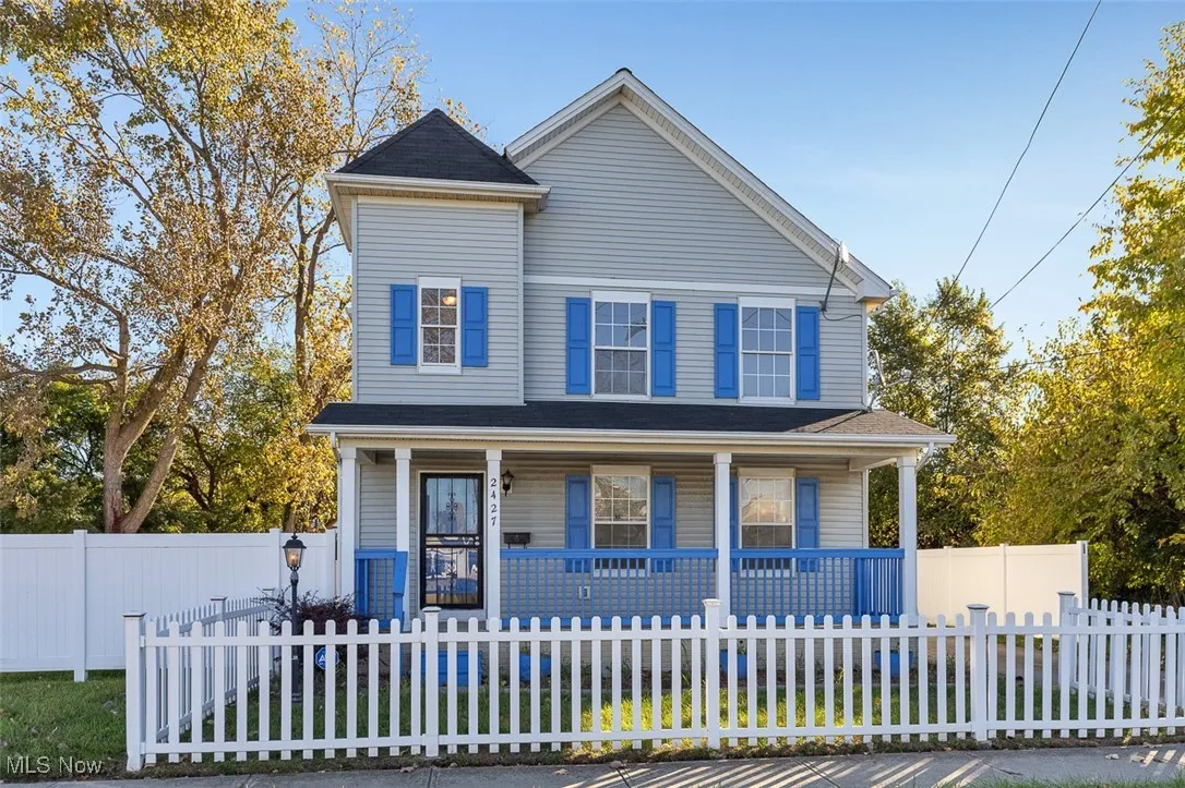 View of front facade featuring covered porch and a fenced front yard