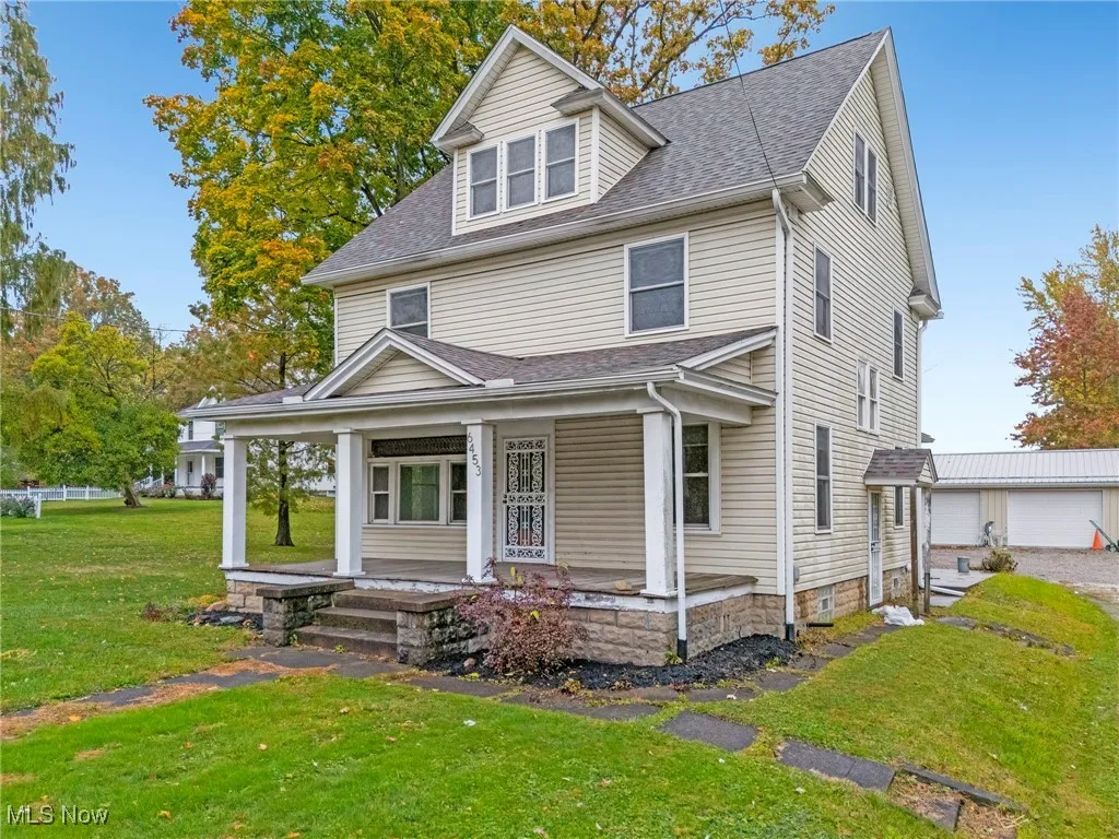 View of front of home featuring a front lawn, a porch, and a shingled roof