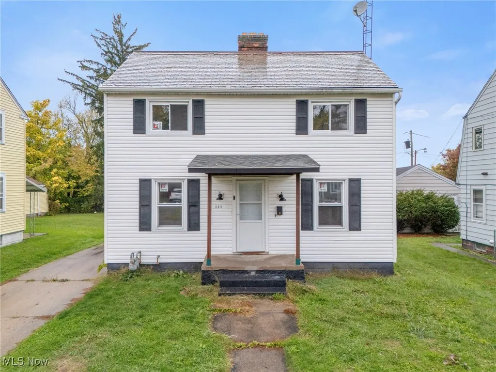 View of front facade with a front lawn and a chimney