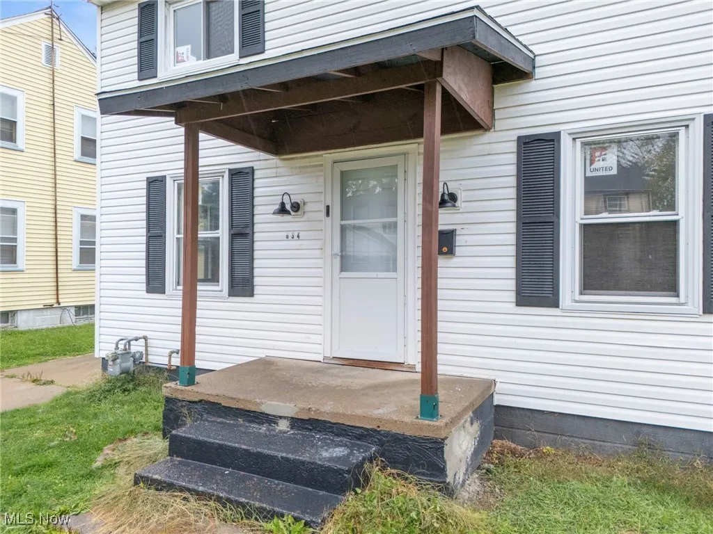 Doorway to property featuring covered porch