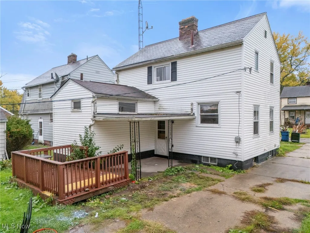 Back of property featuring a patio, a chimney, and roof with shingles