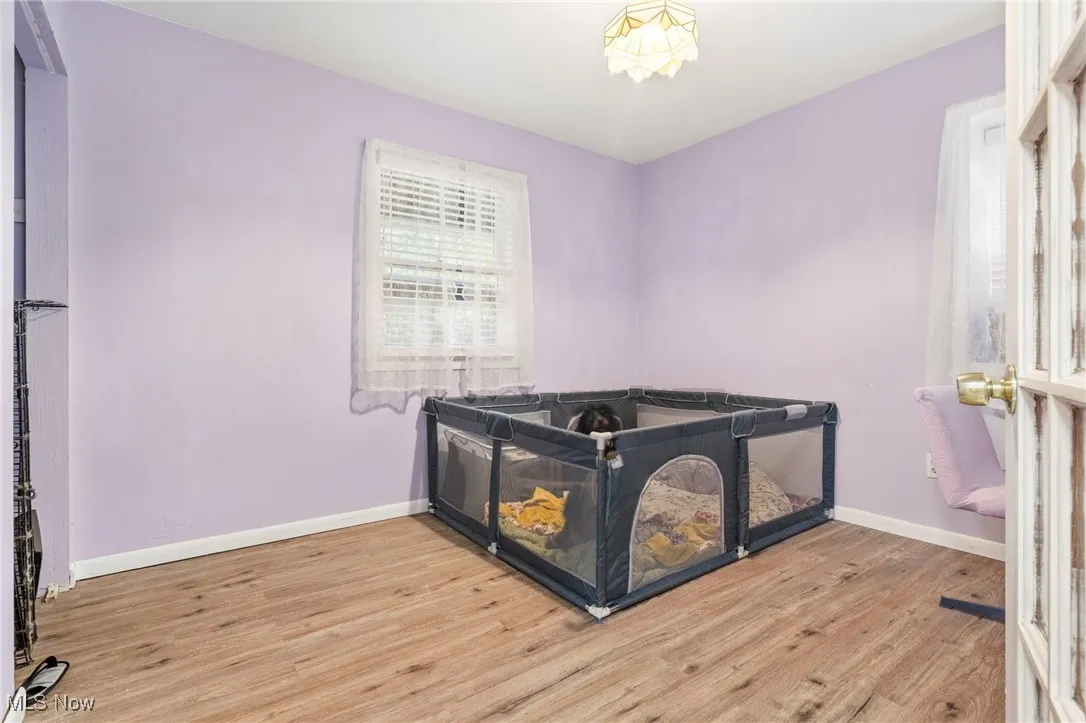 Bedroom featuring wood finished floors and baseboards
