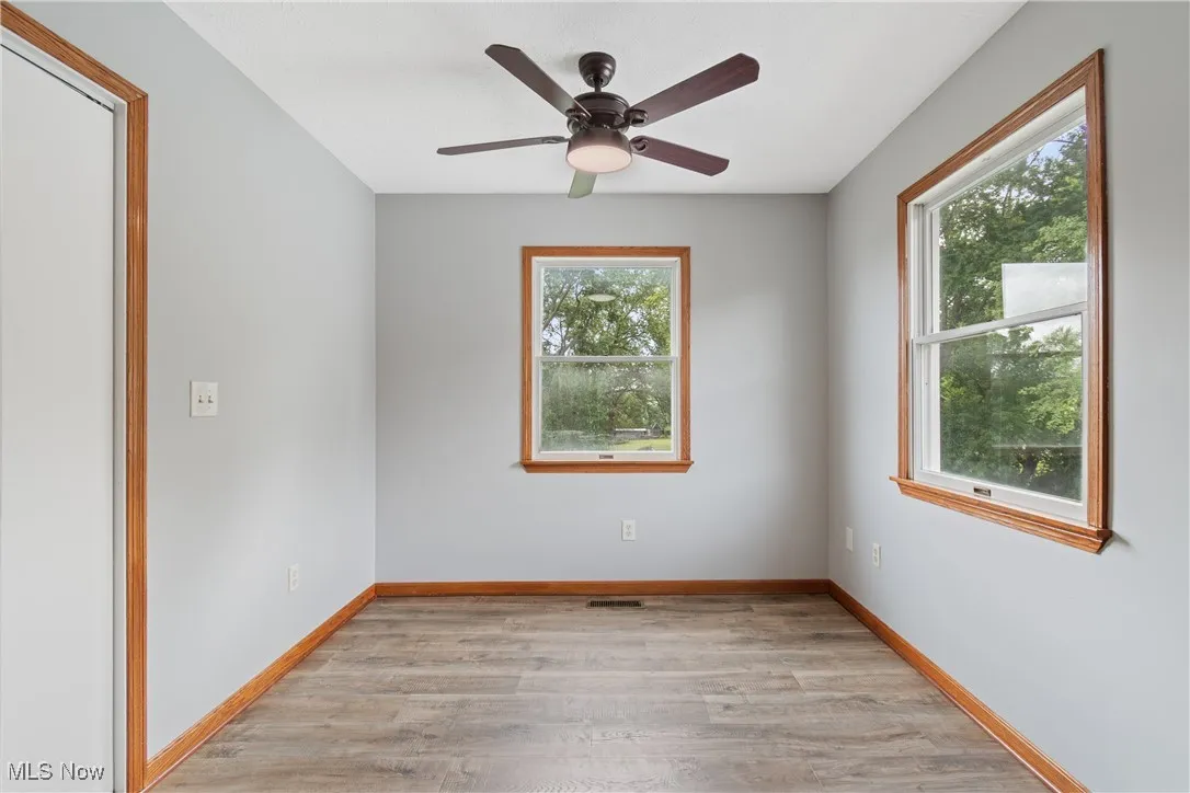 Empty room with light wood finished floors and ceiling fan