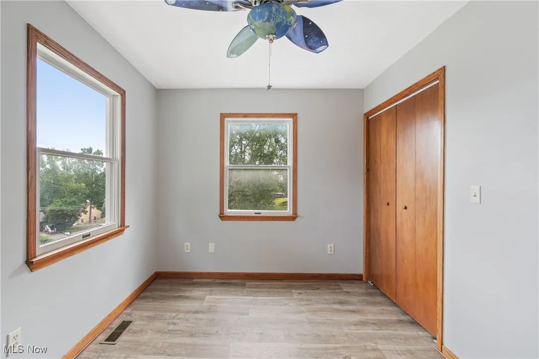 Unfurnished bedroom featuring light wood-type flooring, a closet, and ceiling fan