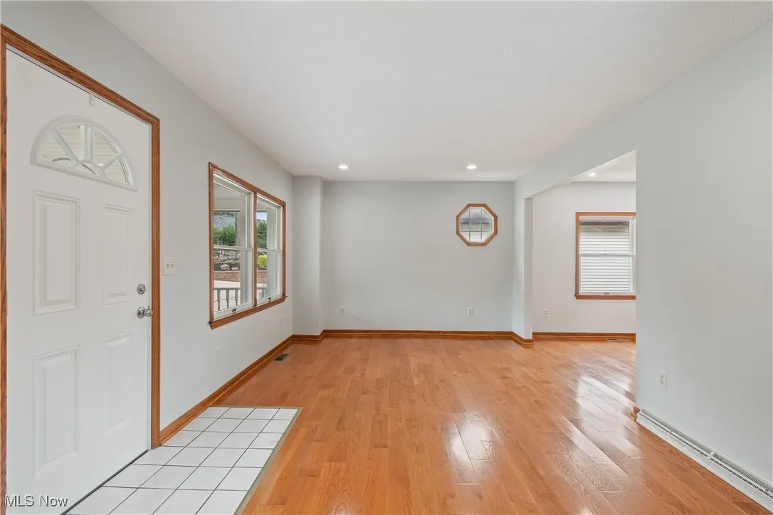Entryway featuring light wood-type flooring, healthy amount of natural light, recessed lighting, and a baseboard radiator