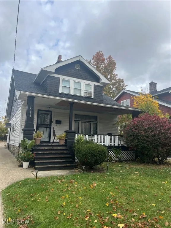 Bungalow with covered porch and a front yard