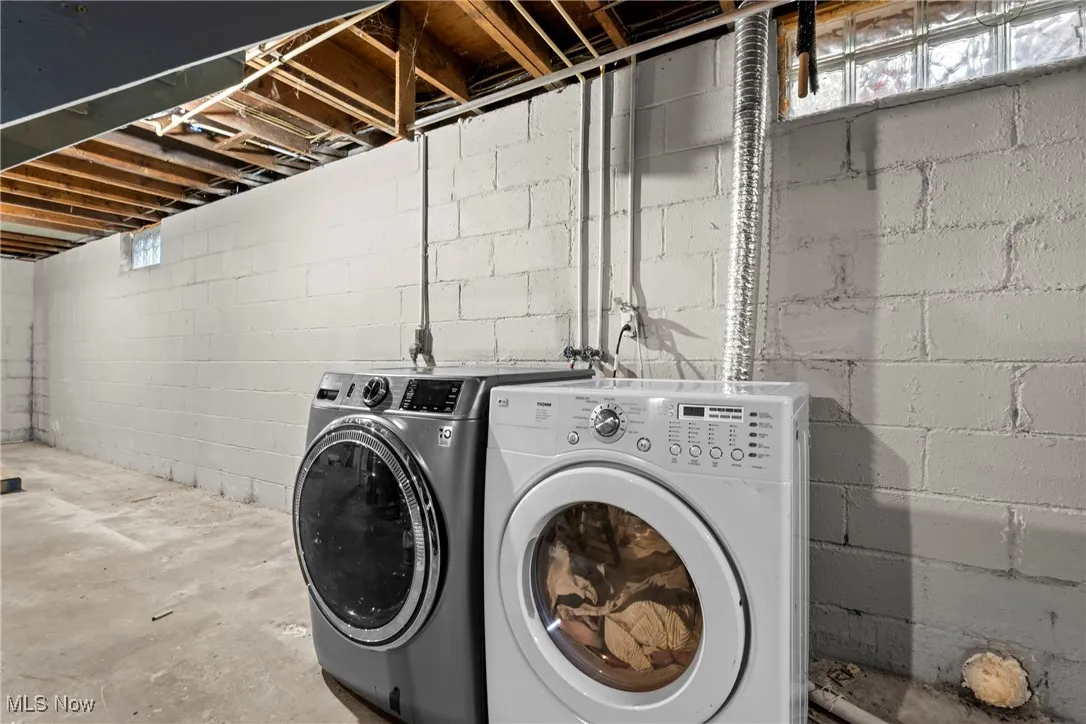Washroom with independent washer and dryer and concrete floors