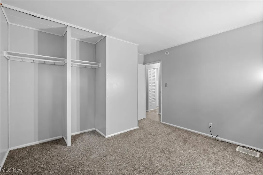 Unfurnished bedroom with carpet flooring and a closet