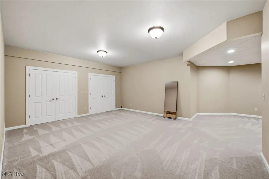 Basement with light carpet and recessed lighting