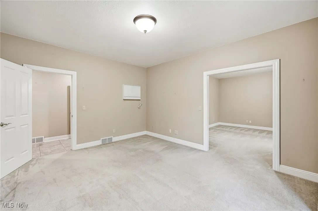 First floor office space/den (2 rooms) featuring light carpet and baseboards