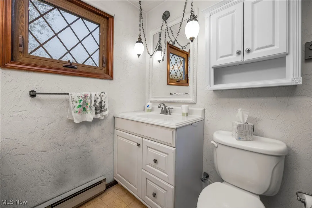 master Bathroom featuring a textured wall, baseboard heating, and vanity