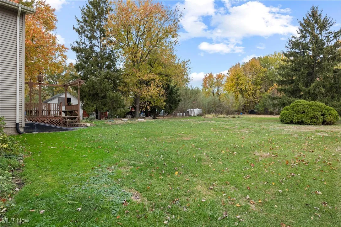 View of green lawn featuring a deck