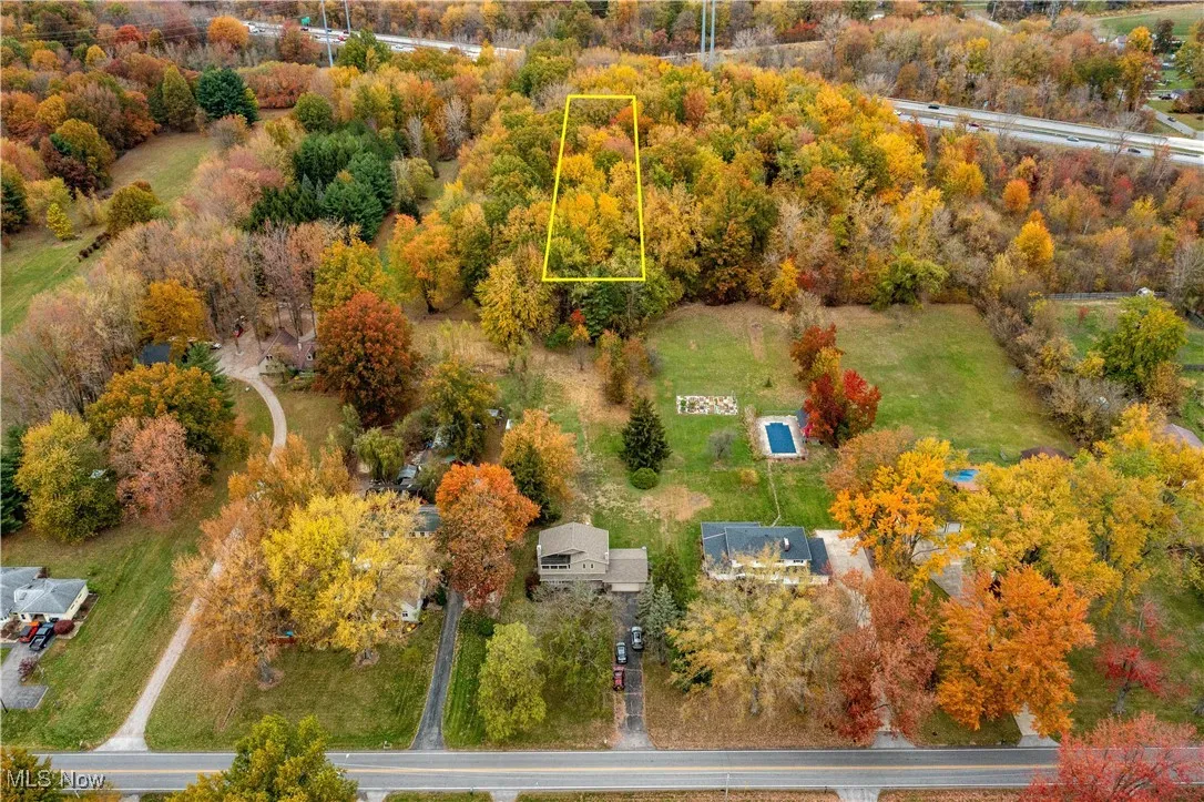 View of property location with property parcel outlined and a tree filled landscape