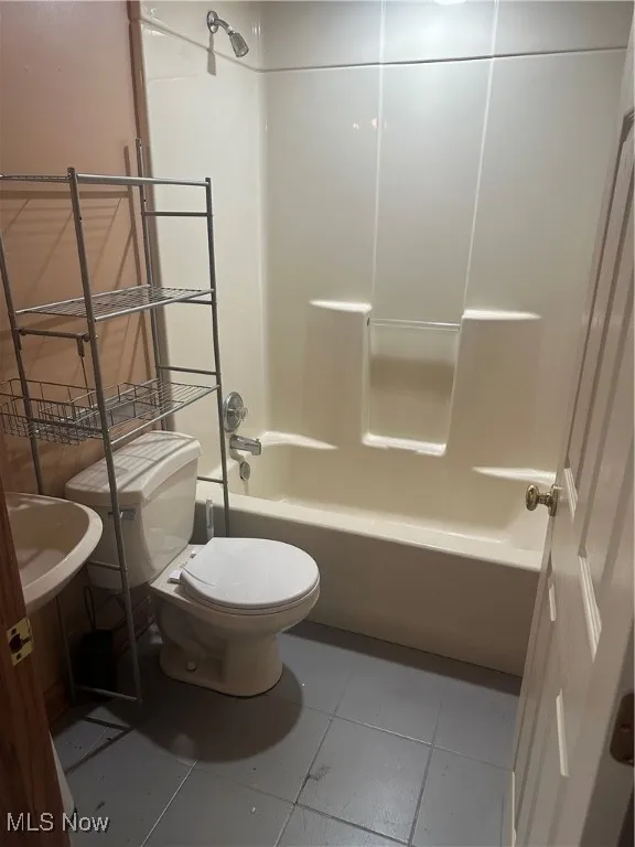 Bathroom featuring light tile patterned floors and shower / washtub combination