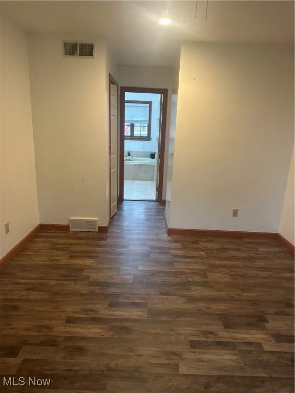 Unfurnished room with dark wood finished floors and recessed lighting