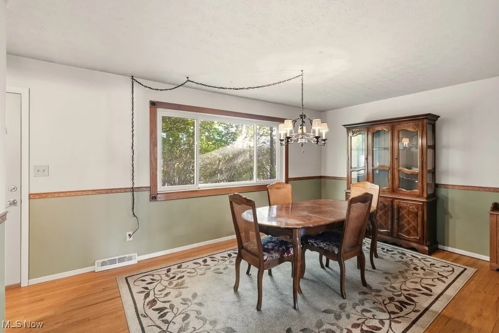 Dining area featuring large windows, light wood-style flooring and a chandelier