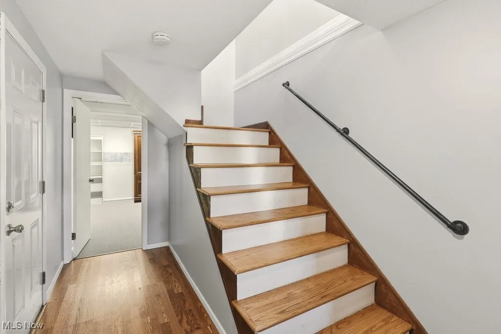 Stairway featuring wood finished floors and baseboards