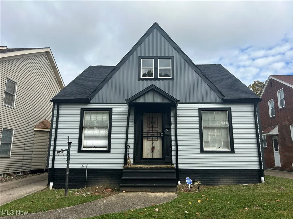 View of front of property with a shingled roof and board and batten siding