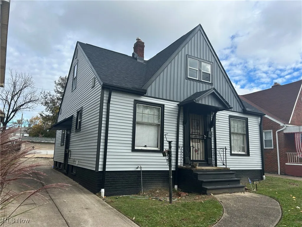 View of front of property with a shingled roof, a chimney, and board and batten siding