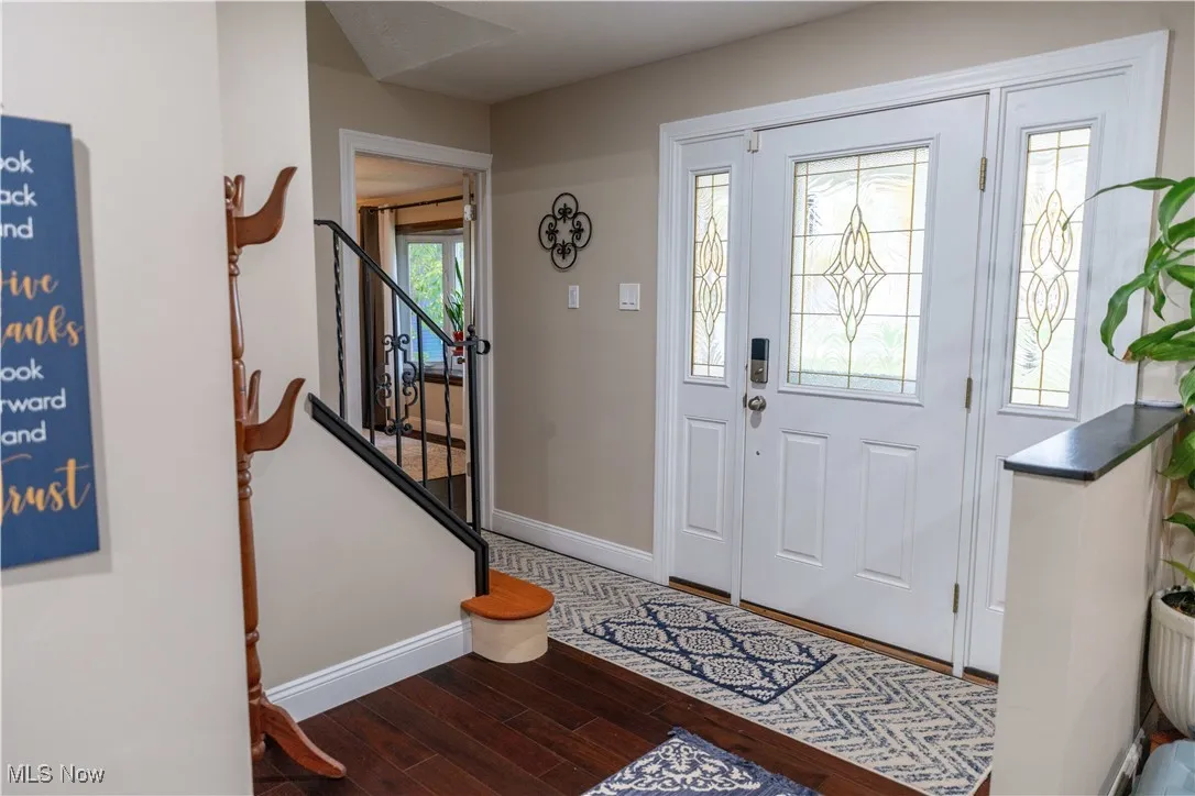 Entrance foyer with dark wood-type flooring and stairway