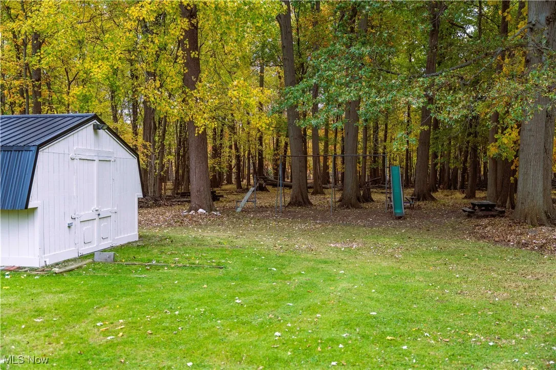 View of grassy yard featuring a storage shed