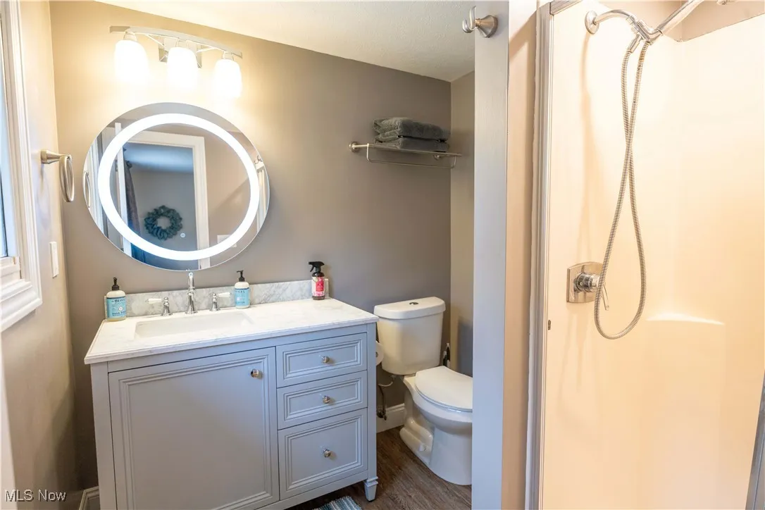 Upstairs en-suite. Full bath featuring a shower, vanity, and dark wood-type flooring