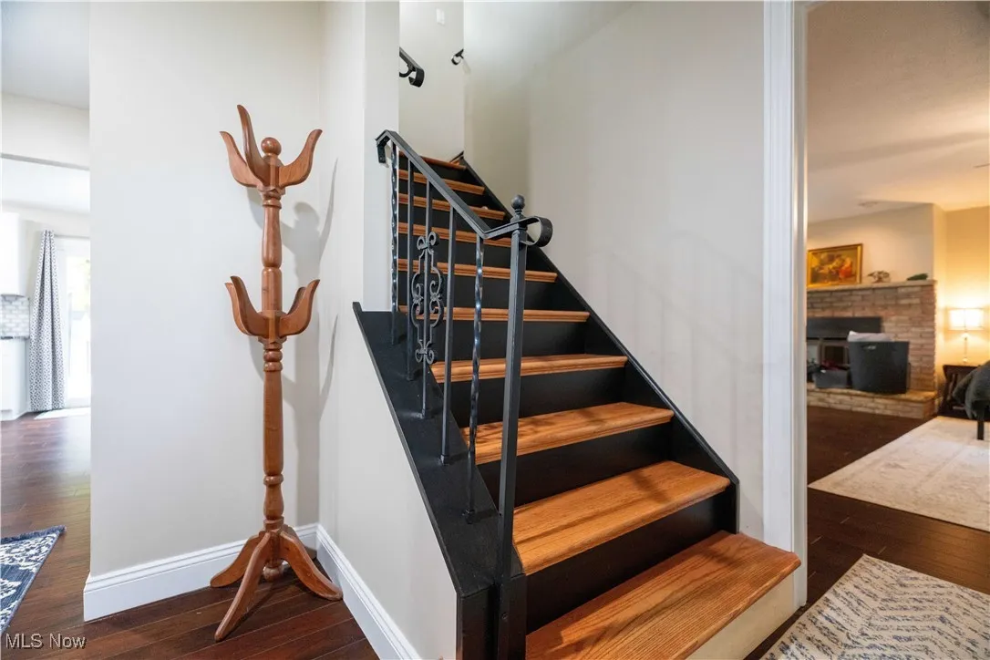Staircase with wood-type flooring and baseboards