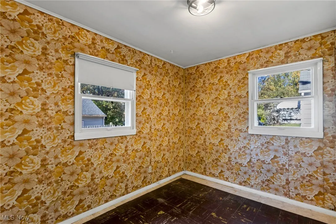 Empty room with baseboards and dark flooring