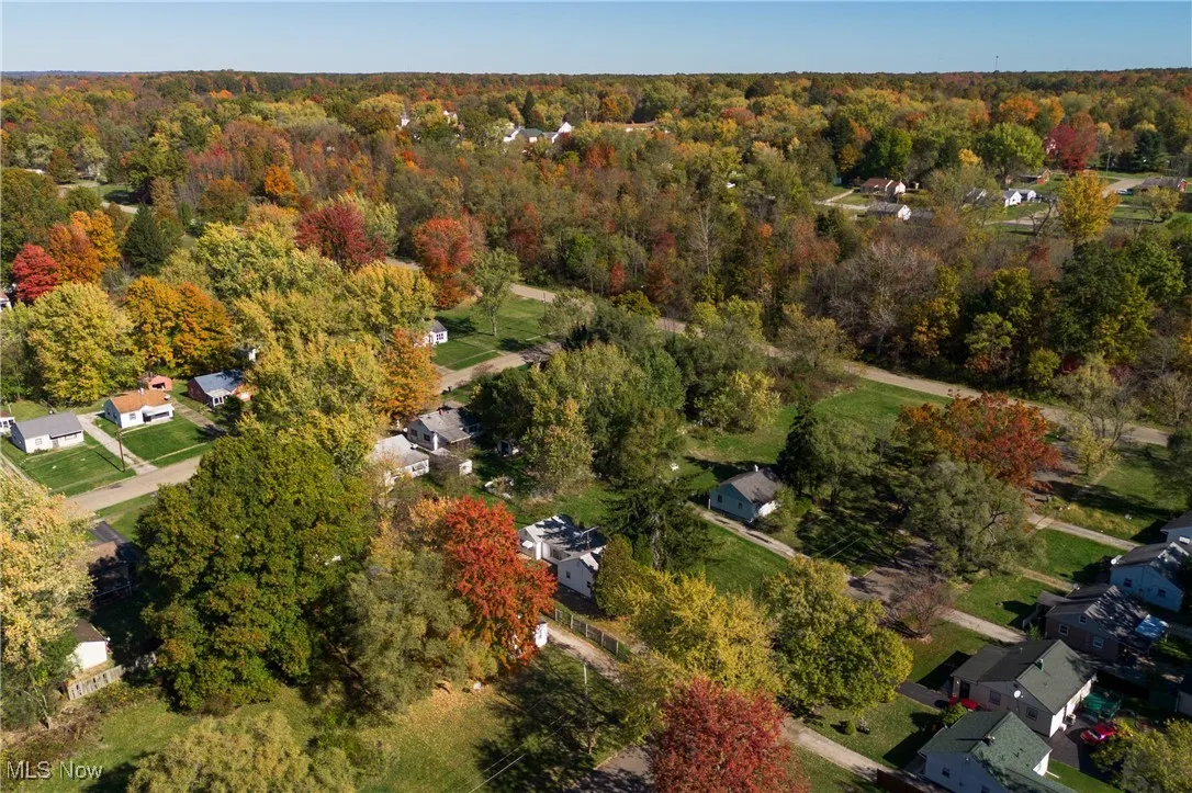 Aerial view of property's location with a forest and nearby suburban area