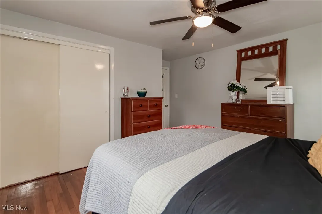 Bedroom featuring wood finished floors, a closet, and a ceiling fan