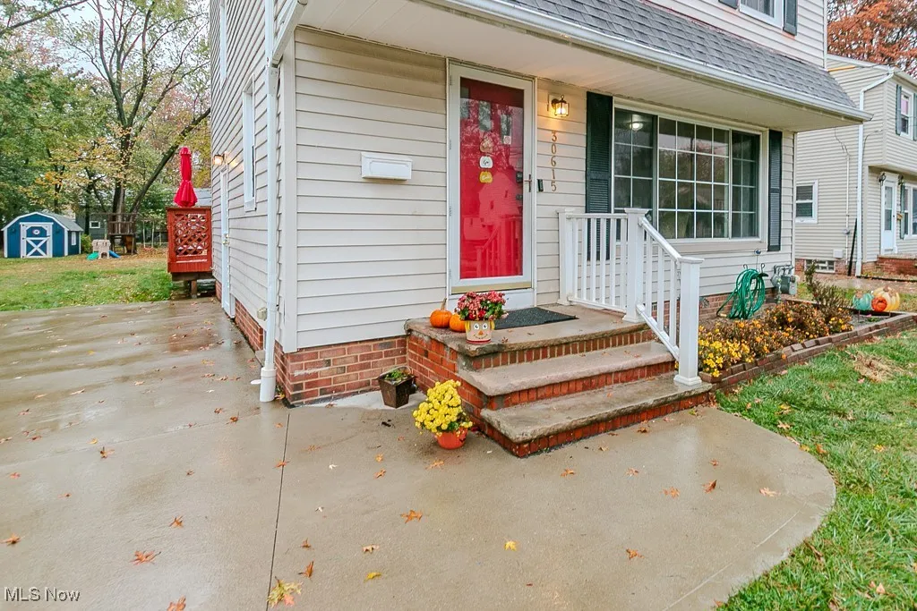 Entrance to property featuring roof with shingles, a patio area, and a yard