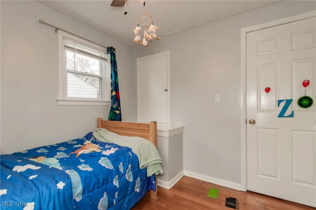 Bedroom with wood finished floors and a chandelier