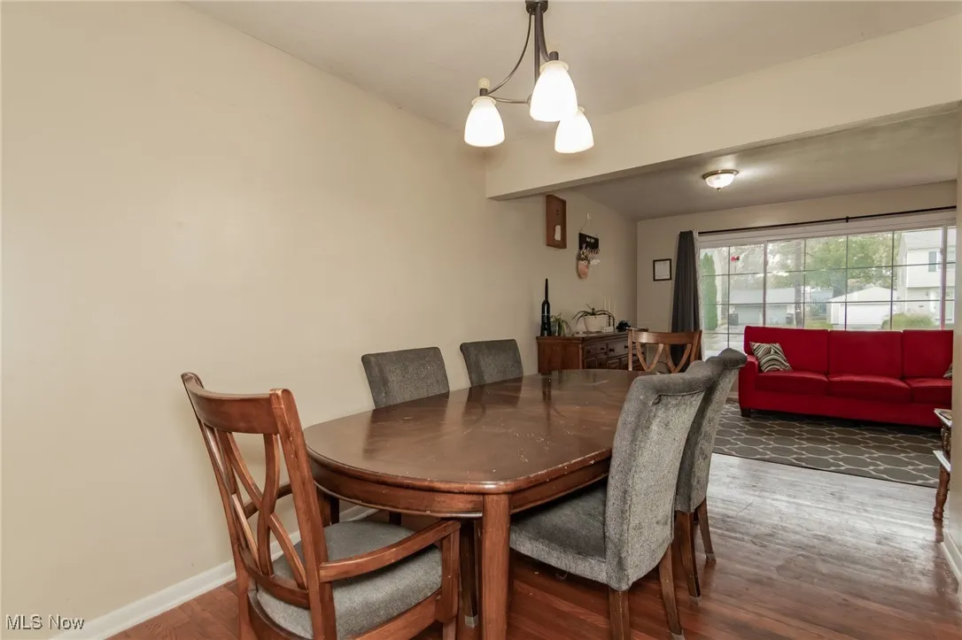 Dining area with dark wood-type flooring and a chandelier