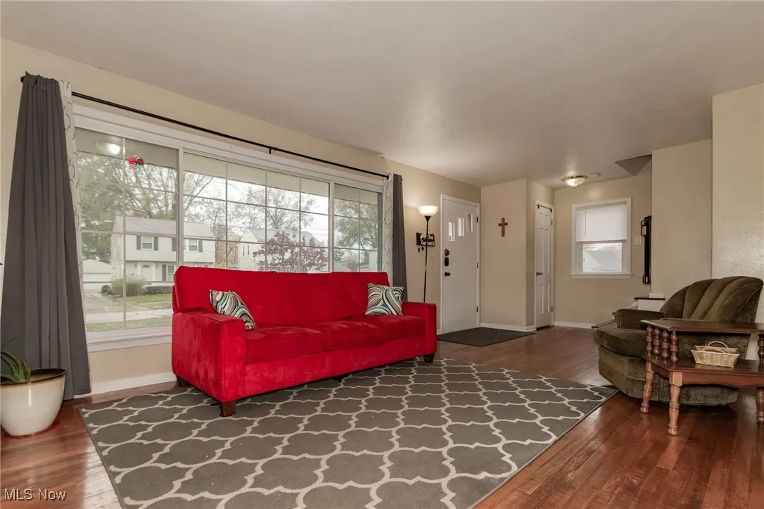 Living area with dark wood-style flooring and baseboards