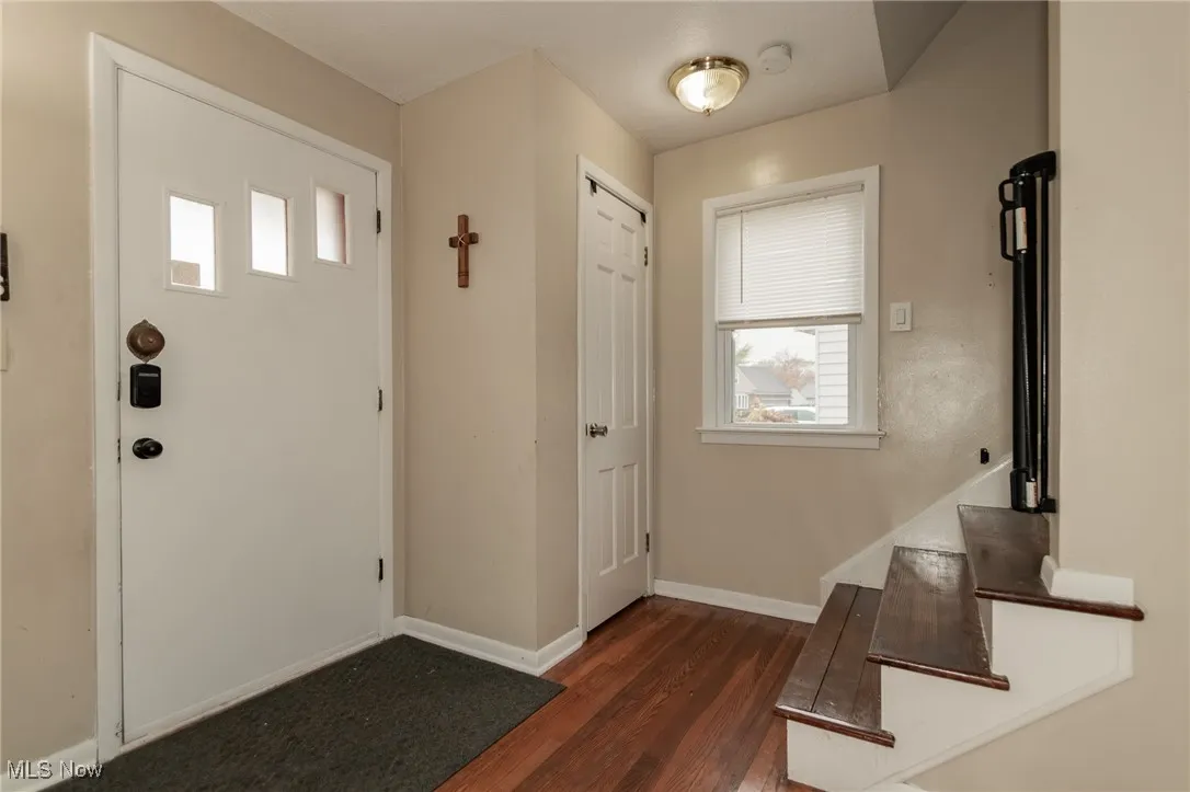Entrance foyer featuring dark wood-style flooring and stairway
