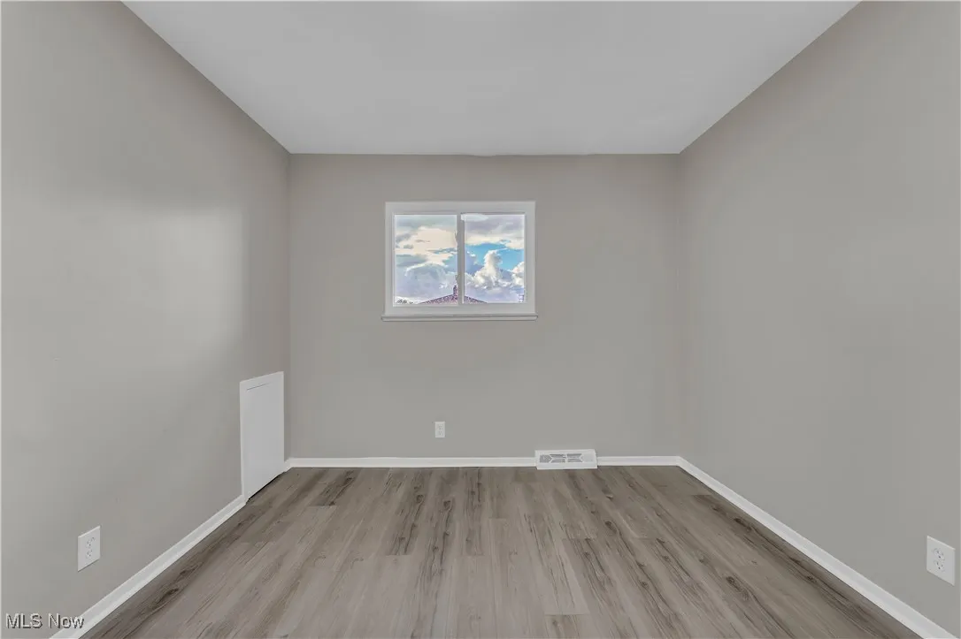 Unfurnished room with light wood-type flooring and baseboards
